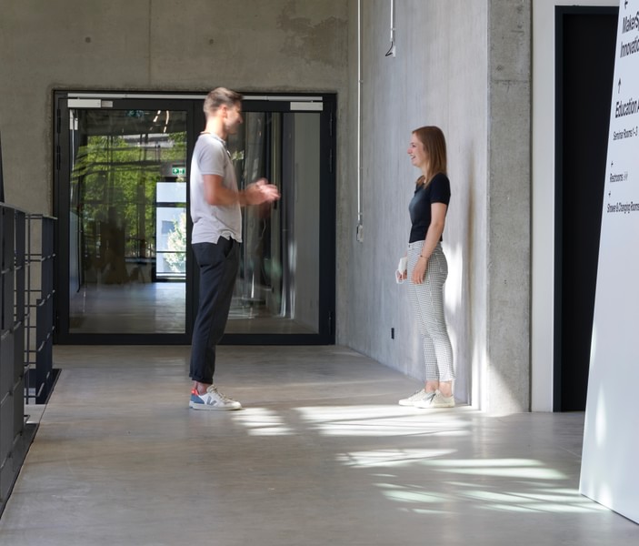 Ein Mann und eine Frau unterhalten sich im Gang des Munich Urban Colab